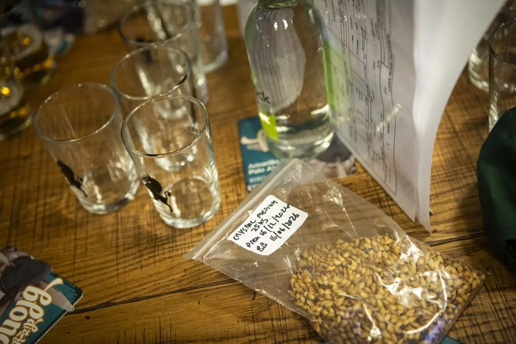 Tasting glasses on a table next to a bag of grains