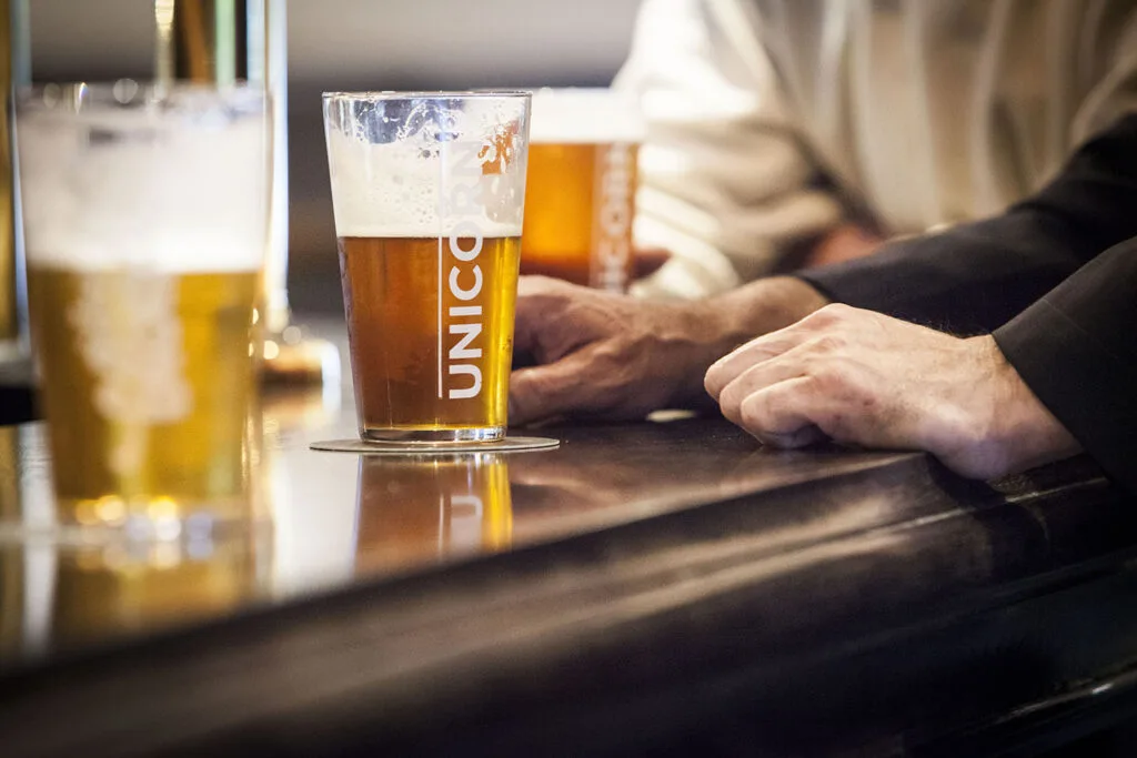 Half drunk unicorn pint on a bar